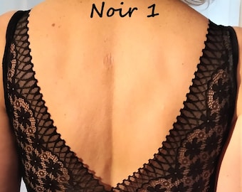 May include: Black lace bralette with a deep V-back. The back of the bralette has a delicate floral lace pattern. The text "Noir 1" is written on the back.