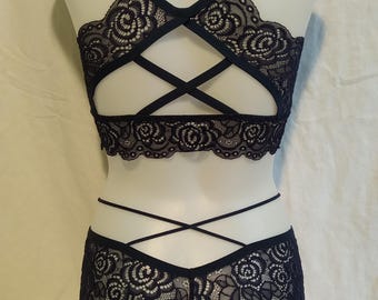 May include: Black lace lingerie set with a criss-cross back design and floral pattern.