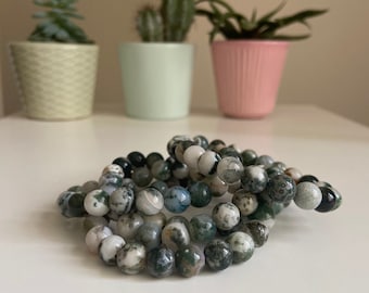 May include: A set of three bracelets made with green, white, and gray moss agate beads.