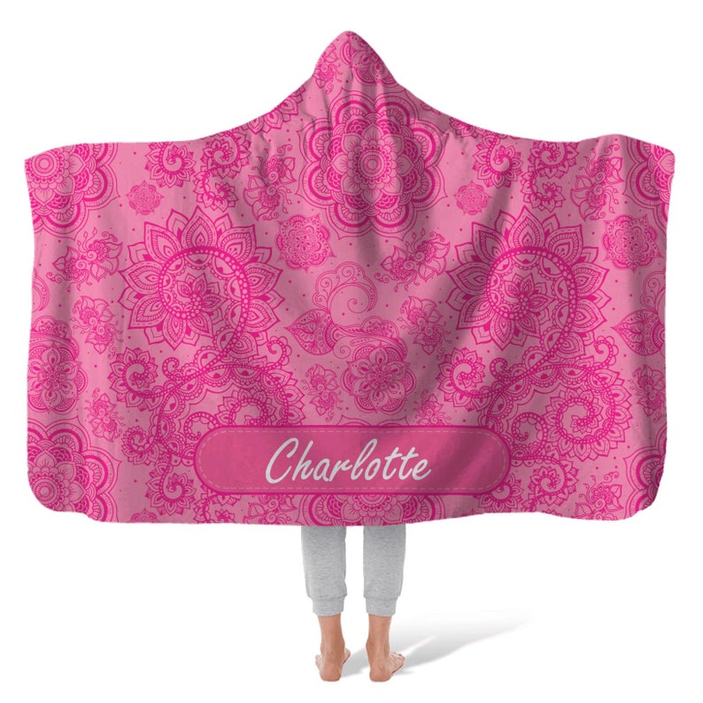 Puede incluir: Manta de capucha rosa con un patr&oacute;n de paisley y el nombre "Charlotte" bordado en la parte delantera.