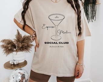 Könnte beinhalten: Ein beigefarbenes Oversize-T-Shirt mit einer schwarzen Grafik eines Martini-Glases und dem Text "Espresso Martini Social Club the foamier the better".