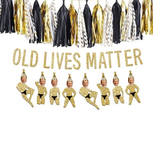 May include: A festive banner with the text "OLD LIVES MATTER" in gold glitter letters. Below are cutouts of men wearing birthday hats with the number 60. Gold, black, and white tassel garland hangs above.