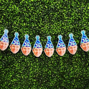 man's face birthday banner with digitally applied blue party hat with age 35, shows 8 custom heads on string