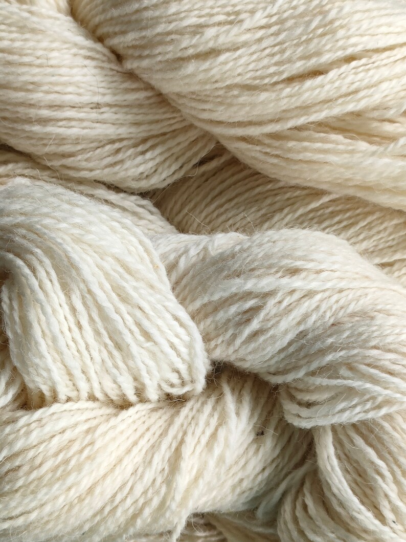 Lana di pecora 100%, naturale, non tinta. Colore bianco, grigio chiaro