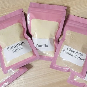 Peut inclure: Cinq sachets refermables roses remplis de poudres aromatis&eacute;es diff&eacute;rentes. Les sachets sont &eacute;tiquet&eacute;s "Pumpkin Spice", "Vanilla", "Chocolate Peanut Butter", "Pumpkin Spice", et "Chocolate Peanut Butter".