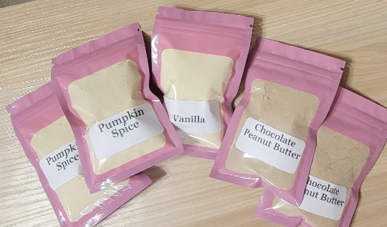 Peut inclure: Cinq sachets refermables roses remplis de poudres aromatis&eacute;es diff&eacute;rentes. Les sachets sont &eacute;tiquet&eacute;s "Pumpkin Spice", "Vanilla", "Chocolate Peanut Butter", "Pumpkin Spice", et "Chocolate Peanut Butter".