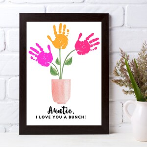 May include: A framed print with a handprint flower bouquet in pink and orange. The vase is a light pink watercolor style. The text reads "Auntie, I love you a bunch!"