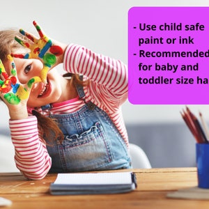 May include: A young girl with colorful paint on her hands smiles at the camera. The text on the pink note reads: "Use child safe paint or ink - Recommended for baby and toddler size hands".