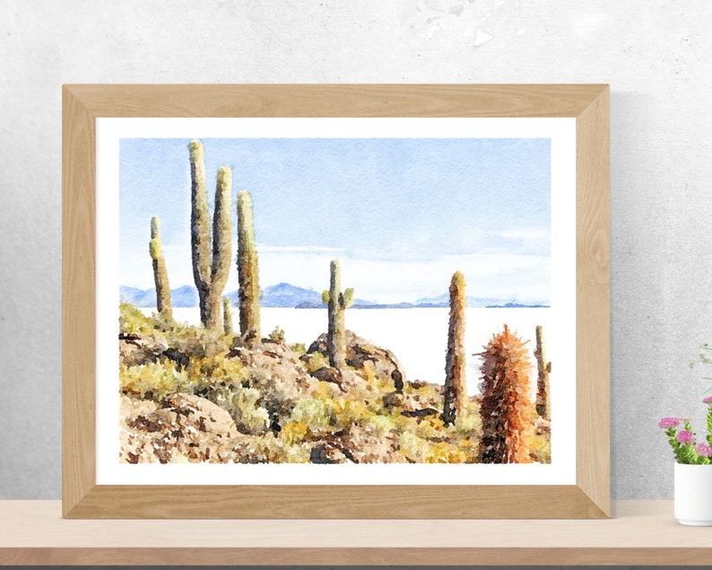 May include: Watercolor painting of a desert landscape with tall cacti and a distant view of a lake. The sky is a light blue and the water is a pale blue. The cacti are green and brown and the rocks are brown and gray.