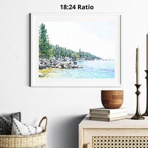 May include: A watercolor painting of a lake scene with a forest in the background. The lake is a light blue color and the forest is a dark green color. The painting is framed in a white frame.