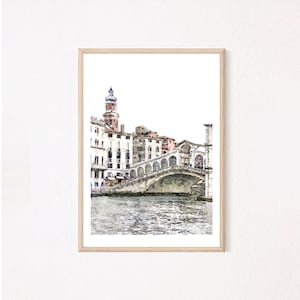 Puede incluir: Impresi&oacute;n en acuarela del Puente de Rialto en Venecia, Italia, enmarcada en madera clara. La obra representa el puente sobre un canal, con edificios y una torre al fondo. La paleta de colores incluye tonos de azul, marr&oacute;n y blanco.
