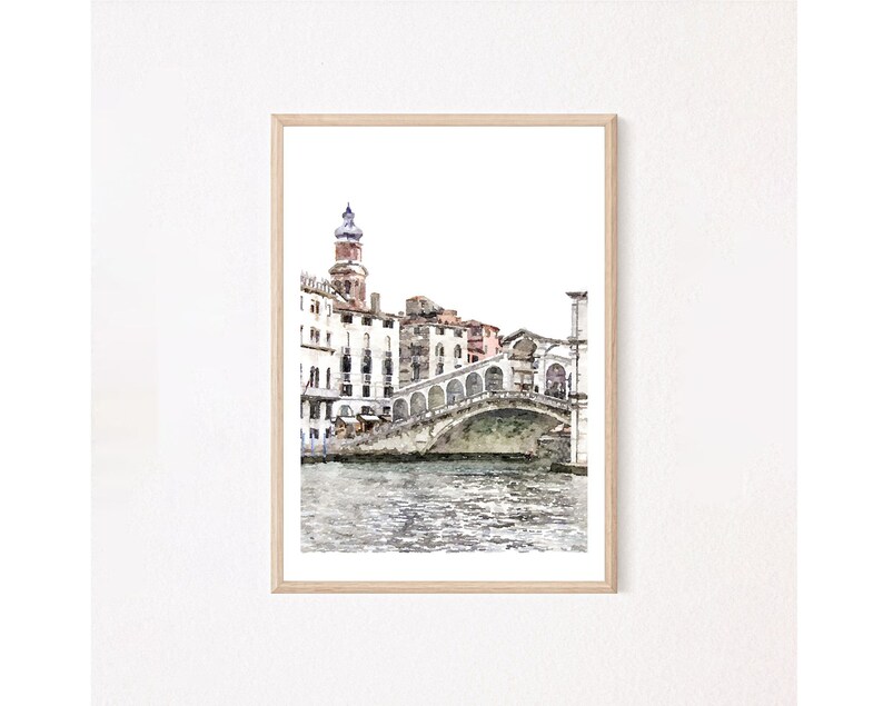 Puede incluir: Impresi&oacute;n en acuarela del Puente de Rialto en Venecia, Italia, enmarcada en madera clara. La obra representa el puente sobre un canal, con edificios y una torre al fondo. La paleta de colores incluye tonos de azul, marr&oacute;n y blanco.
