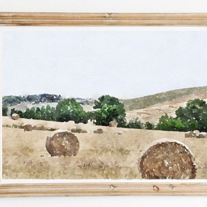 Op de afbeelding: Een aquarel schilderij van een landelijk landschap met hooibalen in een veld. Het schilderij toont een glooiende heuvel met bomen en een blauwe lucht.