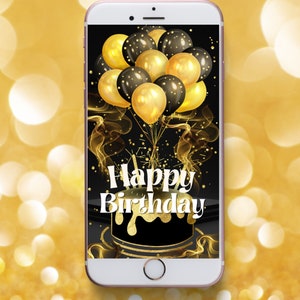 Op de afbeelding: Een zwart smartphone-scherm met een gouden en zwarte verjaardagstaart en ballonnen. De tekst "Happy Birthday" staat in wit op de taart.