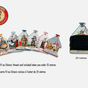 May include: A collection of six decorative cardboard thread cards featuring vintage-style illustrations and the text Fil Au Chinois Sajou, alongside one card wrapped with 25 meters of black thread. The cards are shaped like small houses with a top notch.
