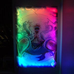 May include: A colorful, framed print of a cartoon character with a single eye, surrounded by swirling smoke and a rainbow-colored border.