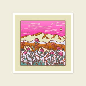 May include: A square art print featuring a stylized landscape. The scene includes a pink sky with a sun, tan mountains, and a field of pink thistle flowers. The artwork is framed in a cream-colored border.