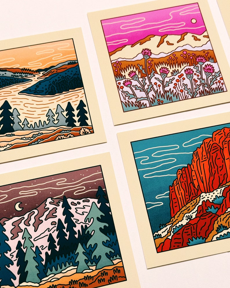 May include: Four illustrated cards featuring different landscapes. The first card shows a sunset over a river with trees in the foreground. The second card shows a pink sky with mountains and purple flowers. The third card shows a night sky with a crescent moon and a snowy mountain range. The fourth card shows a red rock canyon with a blue sky.