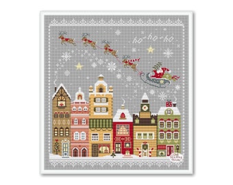 May include: A cross-stitch pattern of a snowy Christmas village with Santa Claus flying overhead in his sleigh pulled by reindeer. The text "ho ho ho" is written in the sky above the village.