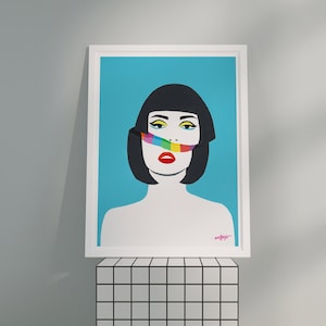 May include: A framed print of a woman with black hair and a colorful stripe across her mouth. The background is a light blue color.