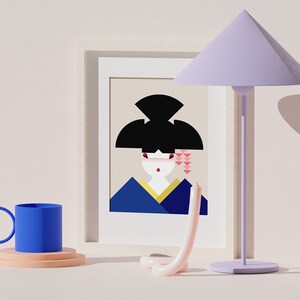 May include: A framed illustration of a woman with black hair and a pink and blue kimono. A blue mug with a handle sits on a pink and white coaster. A purple lamp with a triangular shade sits on a white surface.