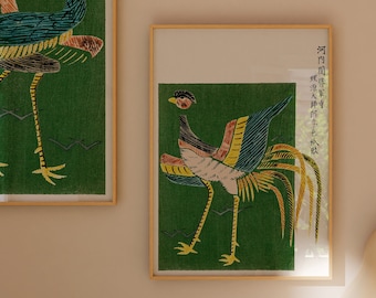May include: Two framed prints of a stylized bird with a long tail, one in a green frame and one in a natural wood frame. The print in the wood frame has Chinese characters in the upper right corner.