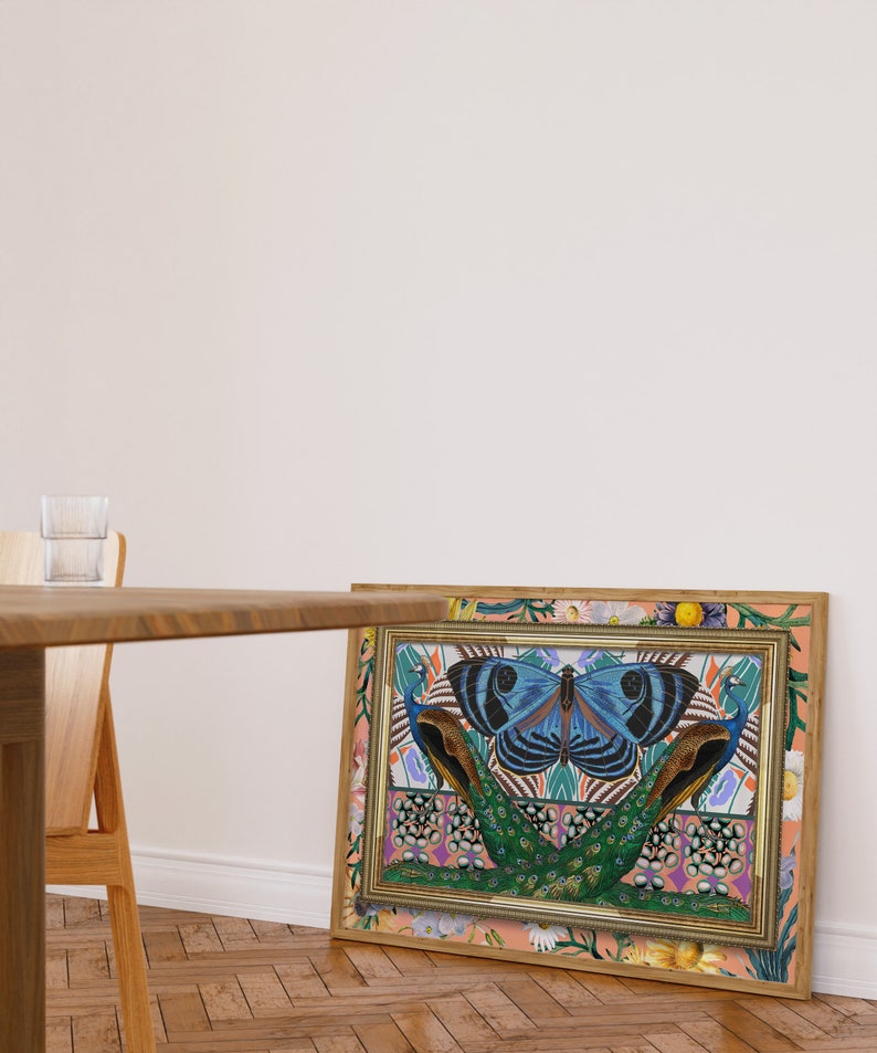 May include: A framed print with a colorful design featuring a large blue butterfly with black markings, two peacocks with green and blue feathers, and a floral border. The background is a peach color with a floral pattern.