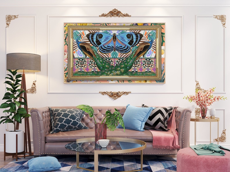 May include: A living room interior with a light pink sofa, two blue pillows, a black and white patterned pillow, a pink throw blanket, a glass coffee table, a blue pillow on the floor, a potted plant, a floor lamp, a side table with a vase of pink flowers, and a framed artwork featuring a blue butterfly with peacock feathers on a colorful background.