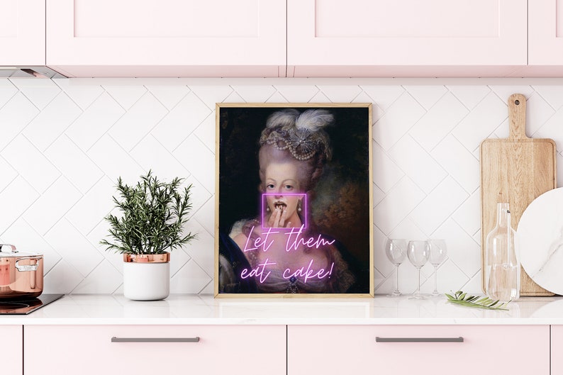 May include: A framed print of a portrait of a woman in a white dress and a large white wig. The woman is holding her finger to her lips and the text "Let them eat cake!" is written below the portrait.