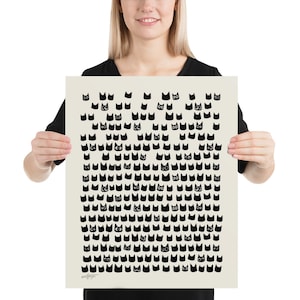 Peut inclure: Une affiche noire et blanche avec un motif de visages de chats noirs sur un fond cr&egrave;me. Les visages de chat sont tous tourn&eacute;s vers l'avant et ont des traits simples et cartoon.