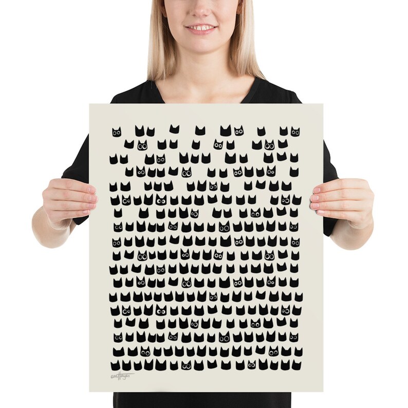 Peut inclure: Une affiche noire et blanche avec un motif de visages de chats noirs sur un fond cr&egrave;me. Les visages de chat sont tous tourn&eacute;s vers l'avant et ont des traits simples et cartoon.