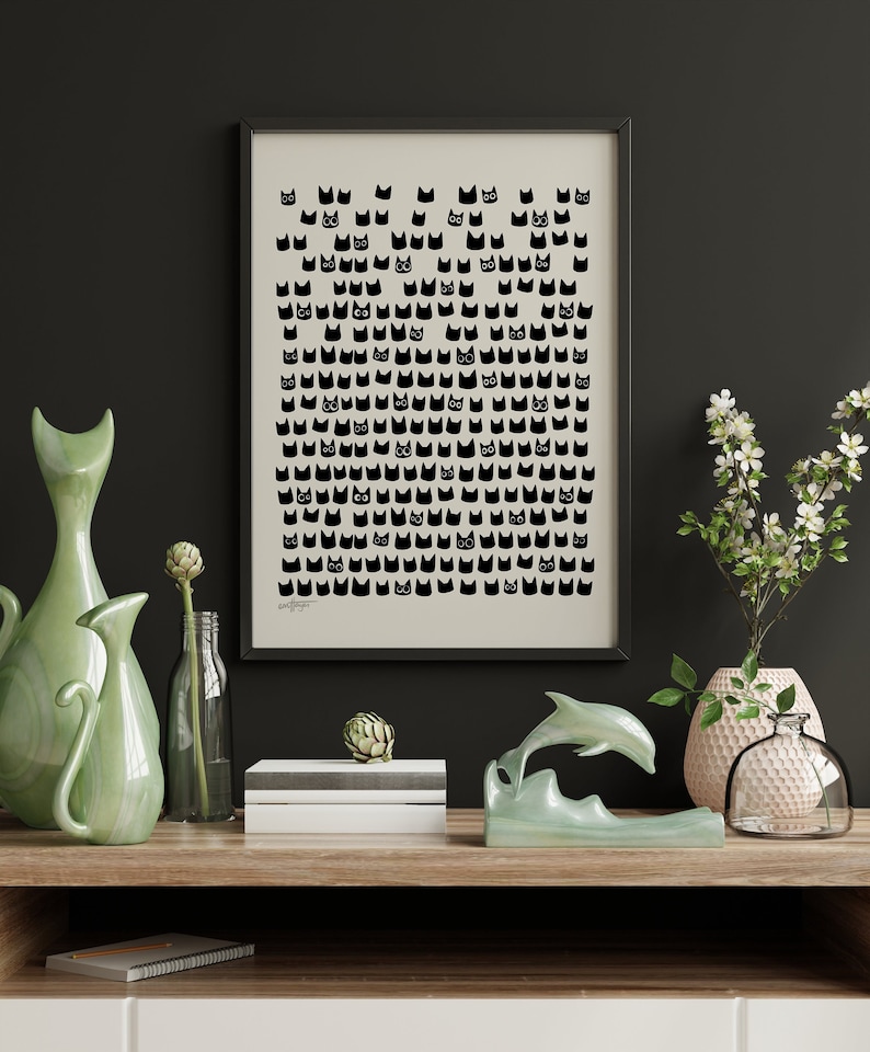 Peut inclure: Une impression noir et blanc d'un motif de chat dans un cadre noir sur une &eacute;tag&egrave;re avec des vases en c&eacute;ramique verts, une sculpture de dauphin verte et un vase blanc avec un motif blanc et or.