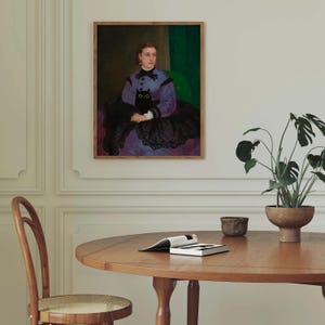 Op de afbeelding: Een schilderij van een vrouw in een paarse jurk met een zwarte kat op haar schoot. De vrouw draagt een zwarte kanten shawl en heeft haar haar naar achteren getrokken. De achtergrond is een groene muur.
