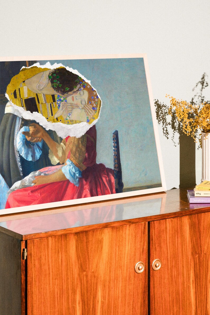 Puede incluir: Una impresi&oacute;n enmarcada de una pintura con un trozo rasgado que revela una pareja bes&aacute;ndose. La pareja est&aacute; representada en un patr&oacute;n amarillo y dorado. La pintura est&aacute; sobre un armario de madera con dos puertas.