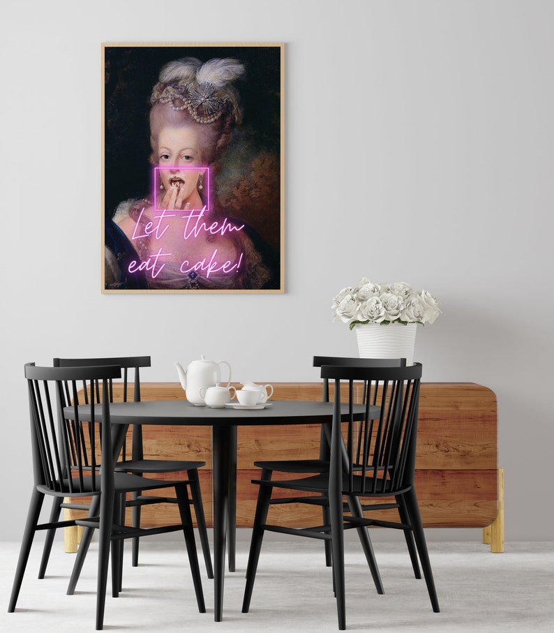 May include: A framed print of a painting of a woman in a white dress and a crown. The woman is holding her hand to her mouth and the text "Let them eat cake!" is written in pink neon letters.