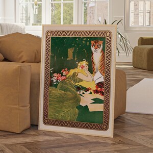 May include: A vintage poster featuring a woman with long blonde hair and a tiger. The woman is wearing a green dress and is sitting in a lush green forest setting. The tiger is standing behind her and looking at the viewer. The poster has a gold and brown border with a repeating pattern.