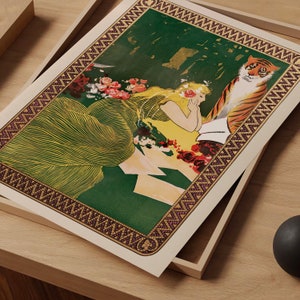 May include: A vintage art print featuring a woman in a flowing green dress with a tiger beside her. The print has a decorative border with a mosaic pattern.