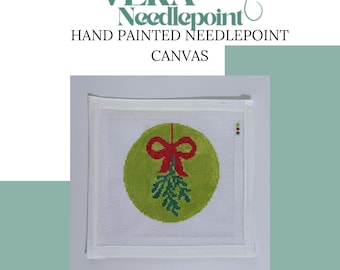May include: Hand-painted needlepoint canvas featuring a green circle with a red bow and mistletoe design. The canvas is square with a white border. The text "VERA Needlepoint" and "HAND PAINTED NEEDLEPOINT CANVAS" are at the top.