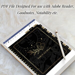 May include: A black and gold tarot journal with a sun and stars design on the cover. The journal has tabs for each month of the year. The journal is displayed on a tablet screen.