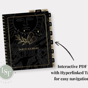 May include: Black and gold tarot journal with a sun and crystal design. The journal has tabs for each month of the year and includes a cover, index, and year section.