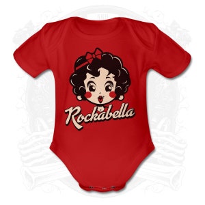 Könnte beinhalten: Roter Baby-Strampler mit einer Cartoon-Illustration eines Mädchens mit einer Schleife im Haar und dem Text "Rockabella".