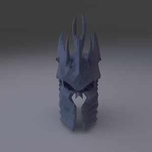 May include: A low-poly, dark gray helmet featuring a crown-like top with multiple sharp, pointed spikes. The helmet has a rigid, faceted geometric structure with a central opening for the face and a vertical guard extending down the front.