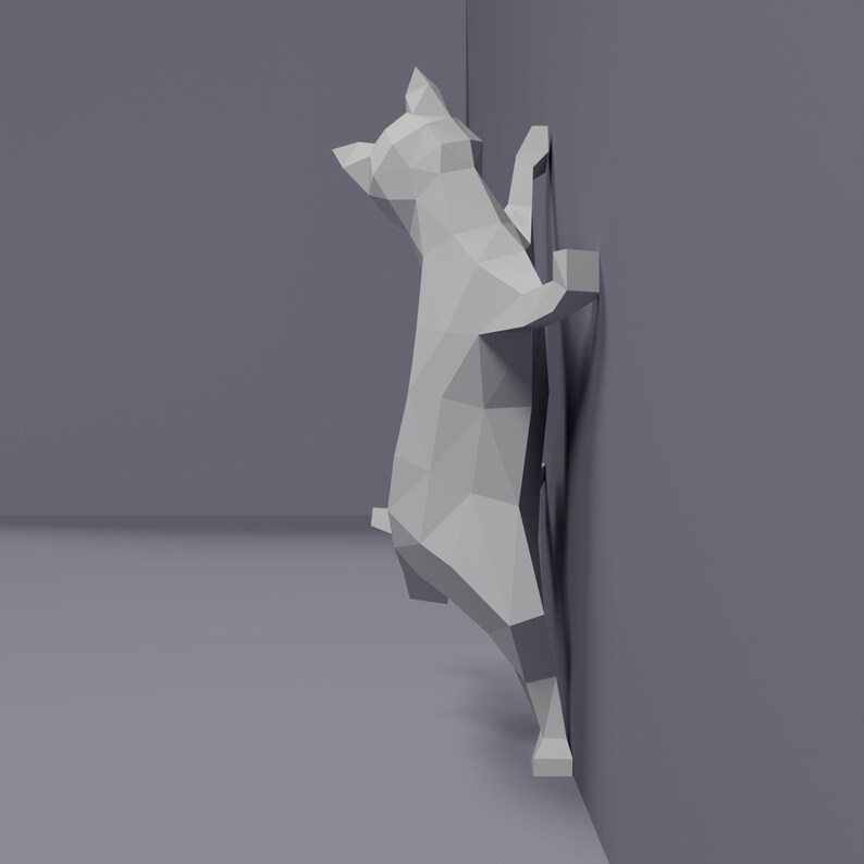 May include: A white, origami-style cat sculpture is climbing a wall. The cat is made of paper and has a simple, geometric design.