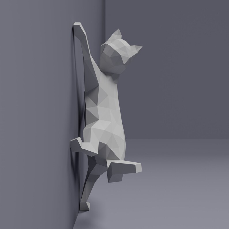 May include: A white, low-poly cat sculpture is climbing a wall. The cat is in a playful pose, with its back legs extended and its front paws reaching up the wall. The sculpture is made of a smooth, white material and has a simple, geometric design.