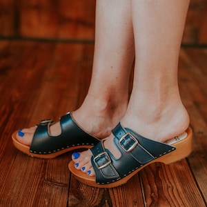 Wooden clogs with open toe made of natural leather in navy and alder wood and two buckles adjusting the length of the upper from Bresco