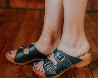 Wooden clogs with open toe made of natural leather in navy and alder wood and two buckles adjusting the length of the upper from Bresco