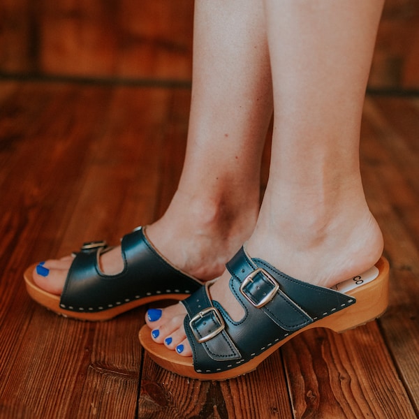 Wooden clogs with open toe made of natural leather in navy and alder wood and two buckles adjusting the length of the upper from Bresco