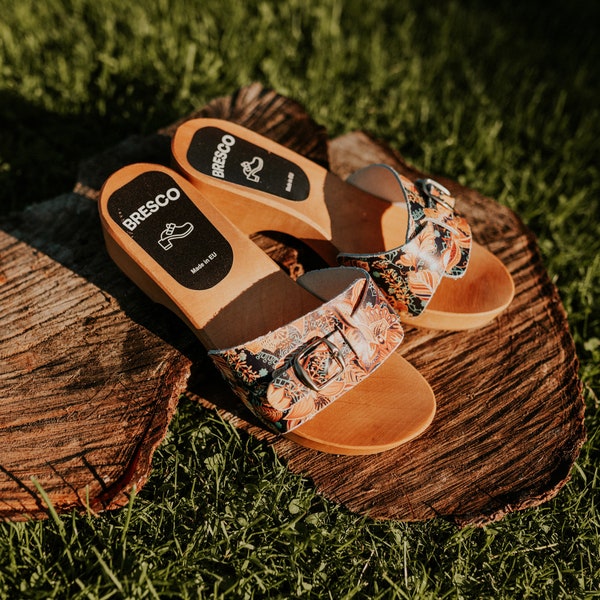 Wooden clogs with open toe made of natural leather in flower orange and alder wood and a buckle adjusting the length of the upper