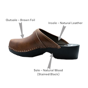 Handmade classic Swedish wooden clogs with a decorative stripe on the upper. Made of natural cowhide in brown leather and black wooden bottom. Available in women and men sizes. Made by BrescoClogs.