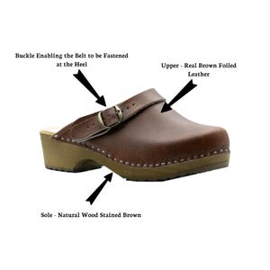 May include: Brown leather clog with a buckle strap and wooden sole. The upper is real brown foiled leather. The sole is natural wood stained brown. The buckle enables the belt to be fastened at the heel.